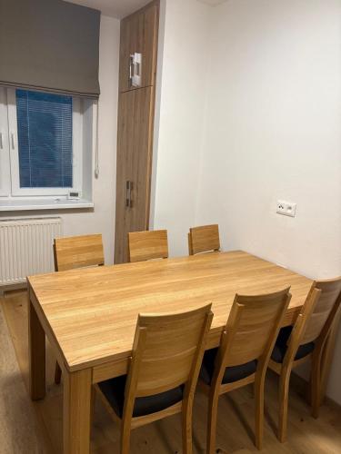 a wooden table and chairs in a room at Apartmány Skalica in Skalica