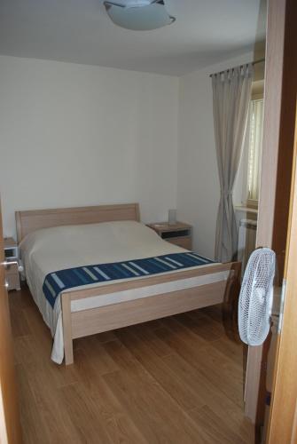 a bedroom with a bed and a window at Apartments Lumbarda Beach in Lumbarda