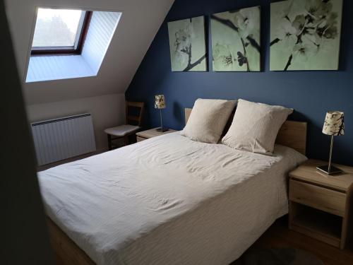 une chambre avec un lit avec des draps blancs et une fenêtre dans l'établissement Gîte Maison de Sophie, à Saint-Aignan