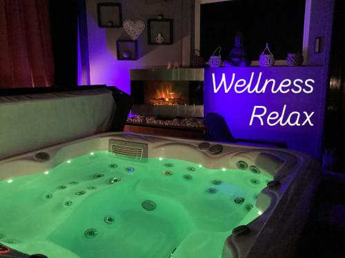 a jacuzzi tub in a room with a fireplace at Relax Apartman in Sümeg