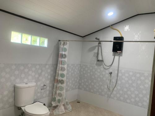 a bathroom with a shower and a toilet in it at Phuchawee Lanta in Ko Lanta