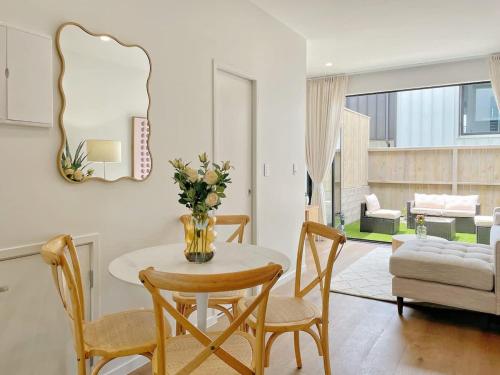 a living room with a table and chairs and a couch at Tranquil Townhouse 2BR & 1 Study with Free Parking & Backyard in Auckland