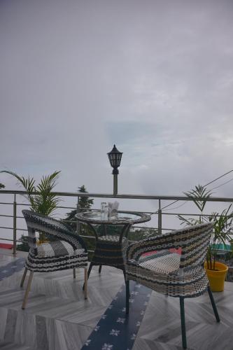 a patio with a table and chairs on a balcony at Sangam by Stotrak, Jhula Ghar Mussoorie in Mussoorie