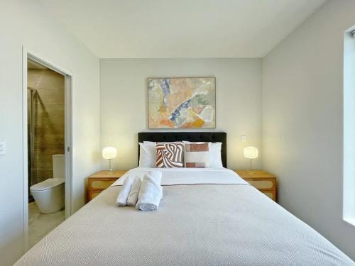 a bedroom with a large bed with two lamps at Tranquil Townhouse 2BR & 1 Study with Free Parking & Backyard in Auckland