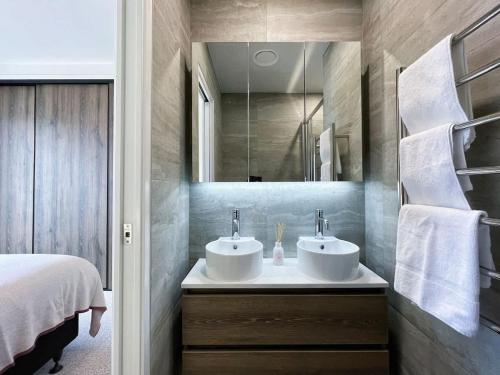 a bathroom with two sinks and a mirror at Tranquil Townhouse 2BR & 1 Study with Free Parking & Backyard in Auckland