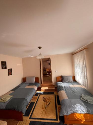 a room with three beds and a window at Platanos Village Home in Tríkala