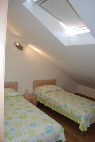 a bedroom with two beds and a sloped ceiling at Apartments Lumbarda Beach in Lumbarda
