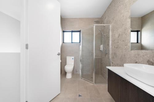 a bathroom with a shower and a sink and a toilet at Whispering Vines in McLaren Vale