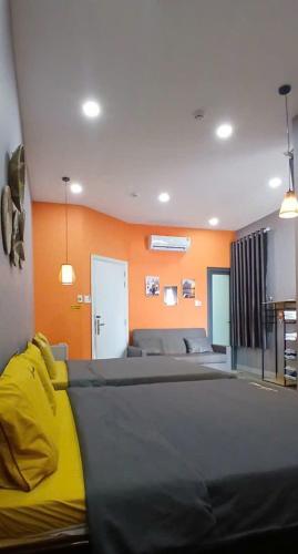 a bedroom with a bed and an orange wall at Thanh Hằng Homestay in Can Tho