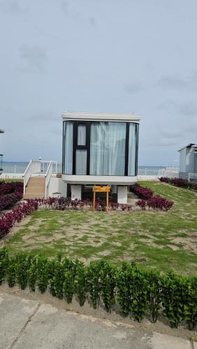 a house sitting on top of a grass field at Saga Village Hotel & Resort Bintan in Pulau Sekerah