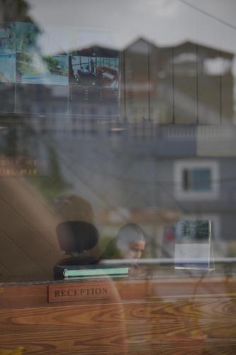 a reflection of a man in a window at Sangam by Stotrak, Jhula Ghar Mussoorie in Mussoorie