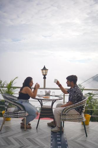 a man and a woman sitting at a table at Sangam by Stotrak, Jhula Ghar Mussoorie in Mussoorie