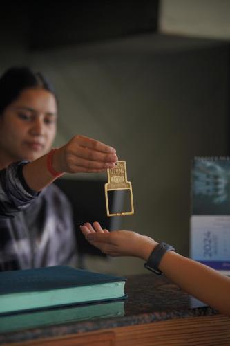 a woman is handing a person a gold medal at Sangam by Stotrak, Jhula Ghar Mussoorie in Mussoorie