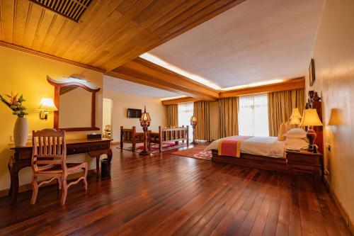 a bedroom with a bed and a desk and a mirror at Bayon Era Hotel in Siem Reap
