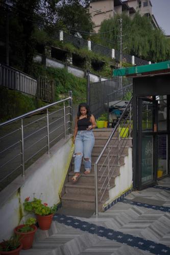 a woman is sitting on the stairs at Sangam by Stotrak, Jhula Ghar Mussoorie in Mussoorie
