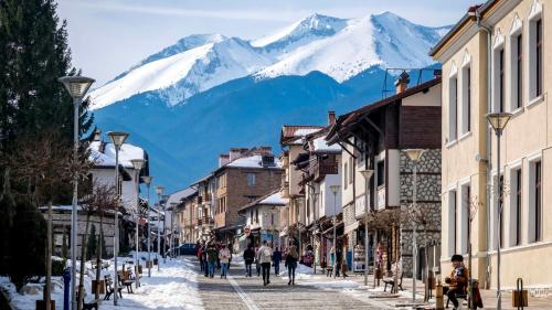 eine Straße in einer Stadt mit einem Berg im Hintergrund in der Unterkunft Bashtin Dom - Skabrin House in Bansko