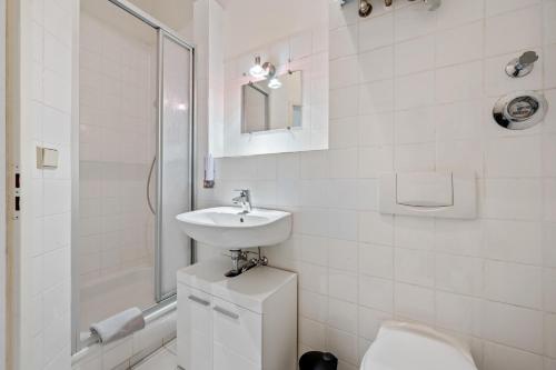 a white bathroom with a sink and a toilet at Apartment 5 min zur Fußgängerzone in Wiesbaden