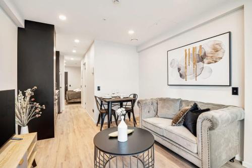 a living room with a couch and a table at Stunning Architecturally Designed Studio in CBD - Pool Gym Sauna in Auckland