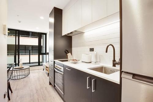 a kitchen with a sink and a counter top at Stunning Architecturally Designed Studio in CBD - Pool Gym Sauna in Auckland