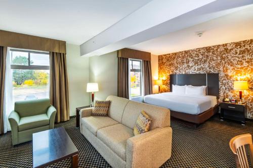 a hotel room with a bed and a couch at Quality Inn & Suites in Petawawa