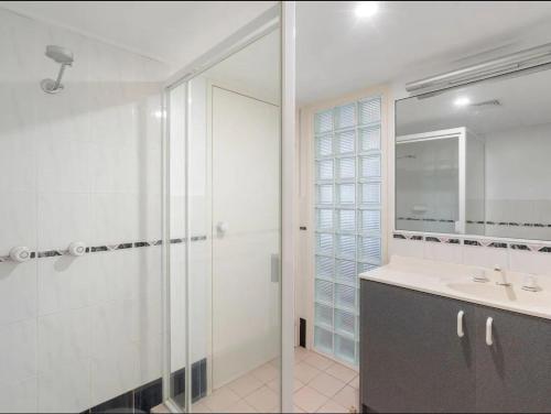 un bagno con doccia, lavandino e specchio di A 3 bedders close to everything a Brisbane