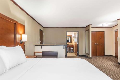 a hotel room with a bed and a desk at Comfort Suites Manhattan in Manhattan