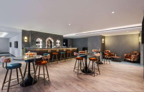 a bar with stools and tables in a room at Doubletree By Hilton Amman Hotel & Residences in Amman