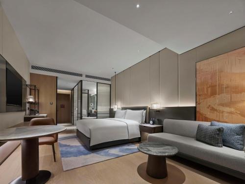 a hotel room with a bed and a couch at Hilton Yuyao in Yuyao