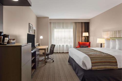 a hotel room with a bed and a desk at Country Inn & Suites by Radisson, Smithfield-Selma, NC in Smithfield