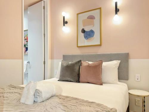 Un dormitorio con una cama con almohadas y un espejo. en Modern Elegance - CBD Luxury 1BR on Central Queen St, en Auckland
