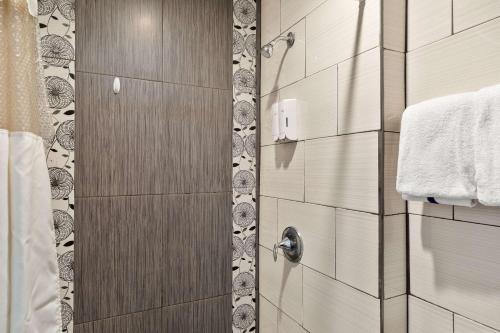 a shower with a wooden door in a bathroom at WindWater Hotel and Marina in South Padre Island