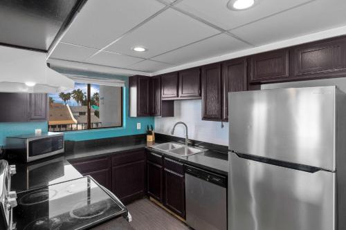 a kitchen with a stainless steel refrigerator and a sink at WindWater Hotel and Marina in South Padre Island