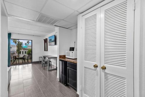 a kitchen and dining room with white walls and a table at WindWater Hotel and Marina in South Padre Island