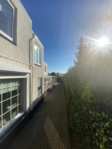 a brick sidewalk next to a building with the sun shining at Hotel Pension Oranje in Valkenburg