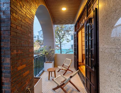 a balcony with two chairs and an archway at Su'e homestay in Hue