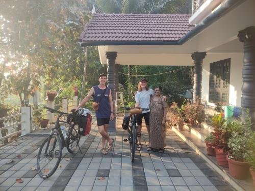 a group of people standing next to a house with their bikes at Munnar Village Homes in Munnar