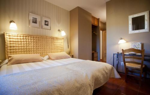 um quarto com uma cama grande e uma cadeira em Hotel Rural El Yantar de Gredos em San Martín del Pimpollar