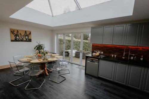 a kitchen with a table and chairs in a room at Cannock Chase Guest House - Modern Super Spacious Renovated home for 6 guests in Huntington