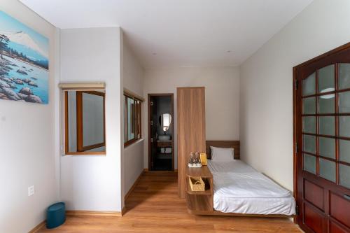 a bedroom with a bed and a wooden door at Su'e homestay in Hue