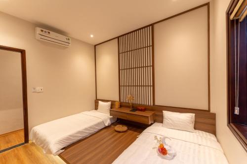 a room with two beds and a table in it at Su'e homestay in Hue