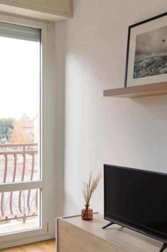 a living room with a flat screen tv next to a window at La Sismonda in Rimini
