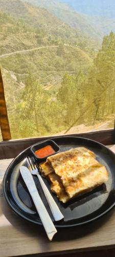 Jaseelo Camps & Resort في Chamba: طبق من الطعام على طاولة مع شوكة وسكين