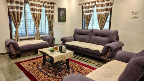 a living room with couches and a table at The ocean's Edge in Revadanda