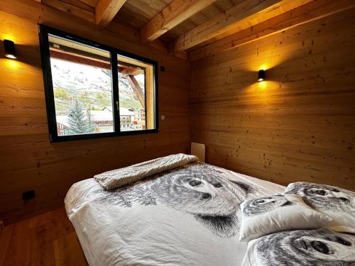 une chambre avec un lit dans une cabane en rondins dans l'établissement Duplex d'exception 8 personnes 83m2 au pied des pistes, proche commerces - Résidence Le Skieur, à Les Deux Alpes