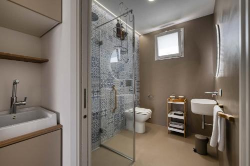 a bathroom with a shower and a toilet and a sink at Villa Zabbara in Favignana