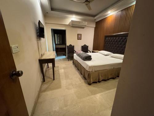 a bedroom with two beds and a desk in it at City view hotel lawrance road in Lahore