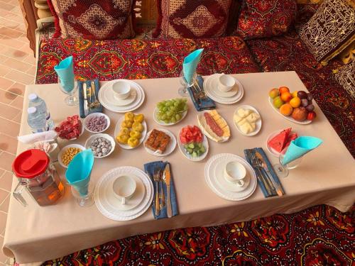 撒马尔罕Mosaic Boutique Hotel的桌子上摆满了食物的盘子和碗