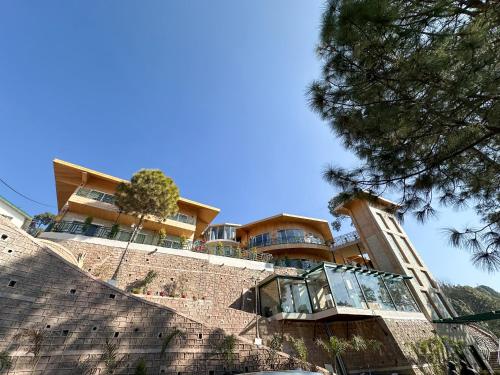 a building on top of a brick wall at Royalpine Rosastays Kasauli in Kasauli