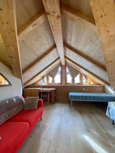 a living room with a red couch and a table at Chalet dei Reparti Bormio in Bormio