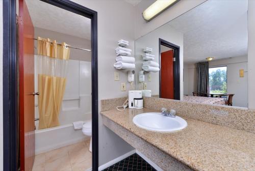 a bathroom with a sink and a toilet and a mirror at Americas Best Value Inn - Augusta / South in Augusta